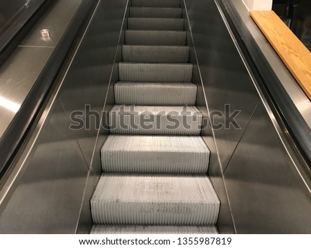 A sliver escalator with nobody at a mall.