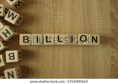 Billion word from wooden blocks on desk Royalty-Free Stock Photo #1356000662