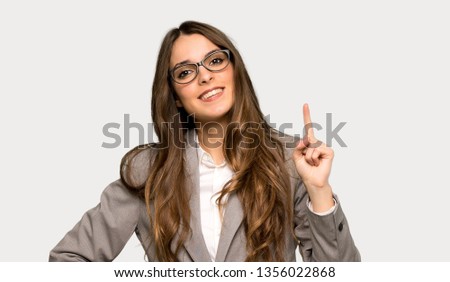 Business woman showing and lifting a finger in sign of the best over isolated grey background