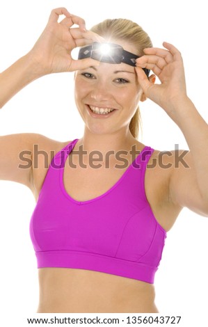 Sporty girl uses bright head lamp for safety while running and jogging isolated on white
