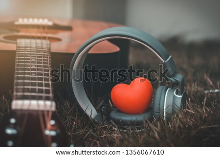 Love music. Red heart and headphones music and guitar in fields. Sound of life. Acoustic music and vintage style. Abstract listening song relaxing in the country. 
