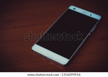 White smartphone on wooden desk