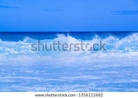 Beautiful seaview - ocean with the large waves and clear pure blue water. People in the sea waves.
