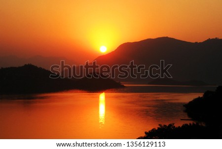 Beautiful sunset and reflection on water Royalty-Free Stock Photo #1356129113