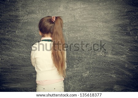 Beautiful smiling girl on a black background. School concept