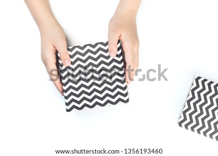 Hands holding Black and white chevron gift boxes isolated on white. Christmas, Valentine, thanksgiving father's day celebration, black friday, shopping or blogger background