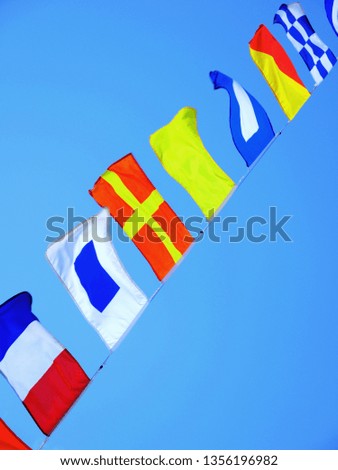 Colorful flags in the wind, blue sky background.