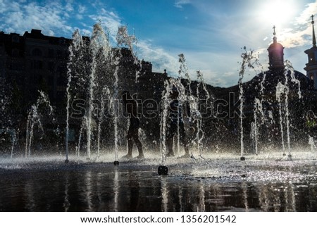Children have fun on a hot day in a dry fountain