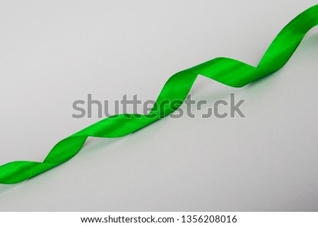 Green ribbon on a gray background. Ribbon for gymnastics. Ribbon for gift.