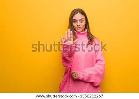 Young modern woman putting hand in front