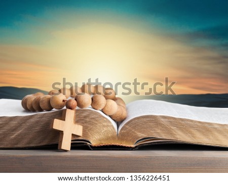 holy bible with eye glasses and note book, pencil   on wooden table with window light in the morning, copy space