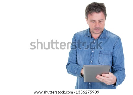 Cheerful middle aged man using tablet computer with side copy space