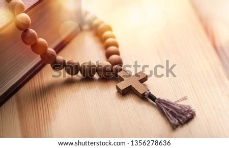 the wooden cross hanged on the bible on top of wood table at church with copy space, can be used for Christian concept or background 
    
    - Image