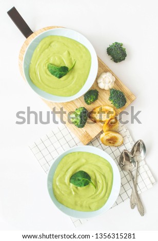 Broccoli cream soup in pastel blue plate on white background. Healthy food concept