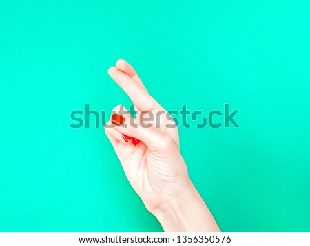 The Fingers Crossed Hand Sign. Cross your fingers when you re hoping for good luck. Hand with crossed fingers on isolated turquoise green color background