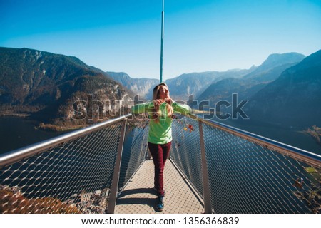 
girl on the viewing platform on the background of mountains and lake