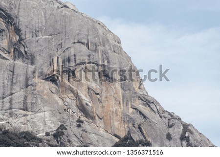A close up of Moro Rock in Sequoia National Park. The smooth granite slabs of rock where people climb to the top by more than 100 steps. Can see the watermarks on the rock. Landscape view.
