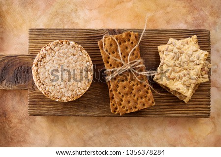 Three types of diet bread. Round buckwheat crispbread, wheat crispbread and crispbread with sunflowe on wooden vintage cutting board and textured background