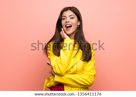Teenager girl over pink wall surprised and shocked while looking right