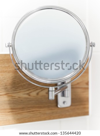 Round wall mirror for the bath. Close-up photo with selective focus