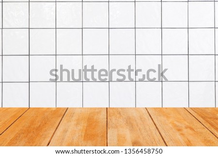 Empty wooden table top with copy space, white tiles wall background.
