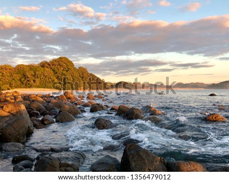 Waves lapping on rocky shore at sunrise , overlooking the cliff