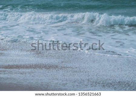 Soft pastel foam waves,and warm brown sand.