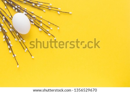 White Egg with decorative twig on yellow background .Christian religious holiday. Happy Easter. Top view. Flatlay