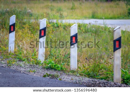 restrictive posts on the railroad. white with reflectors pillars