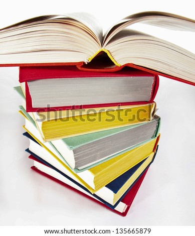 Multicolored stacked books on neutral background