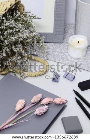 Gray note with frame, white flowers and pencils