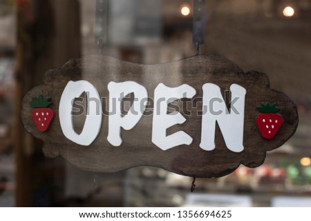 Welcome open sign on door of cafe shop.