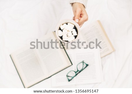Cup  with coffee and in women's hands.Open books,glasses.Top view.White background.
