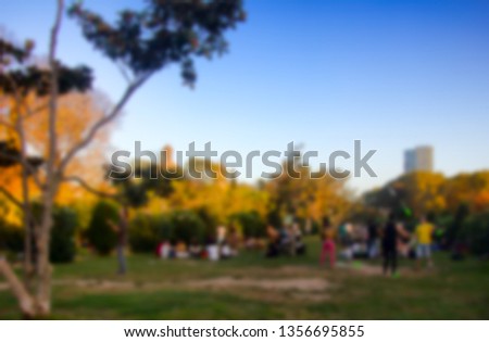 Young people lying on the lawn, fancy place. Strong blur, anonymous people on the streets of Europe