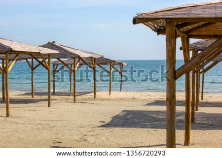 Umbrellas In Sand On Empty Beach