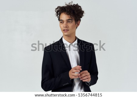 young man in shirt and black jacket curly hair cut view  