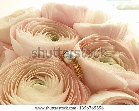 Engagement ring in a pale pink flower bouquet