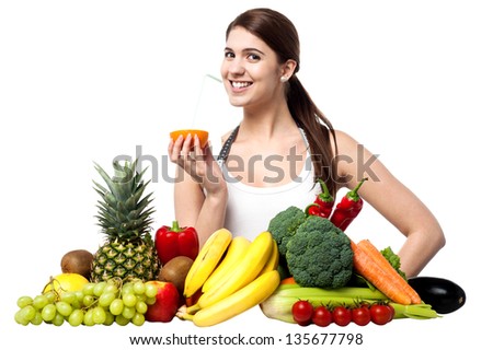 Picture of beautiful woman with fruits and vegetables, enjoying fresh orange juice.