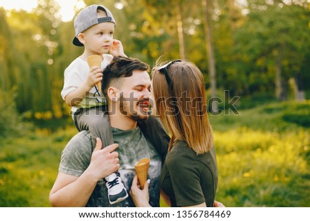 Family in a park. Mother and little son standing in a summer forest. Little boy with ice cream. Couple in a park with cute son