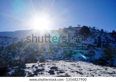 The snowed in Psiloritis mountain of the Mount Ida mountain range, known variously as Idha, Ídhi, Idi, Ita, crete, greece, with blue sky, some clouds and some detail photography                       