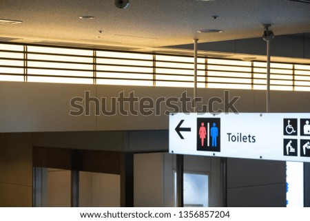 Public restroom signs with a disabled access symbol at airport.
