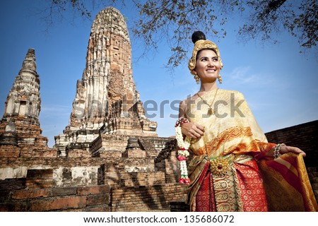 woman wearing typical thai dress with thai style temple background, identity culture of thailand