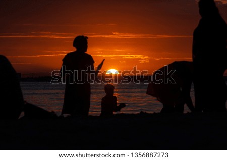 High contrast silhouettes of people on the beach during the sunset- Isla Mujeres - Mexico.