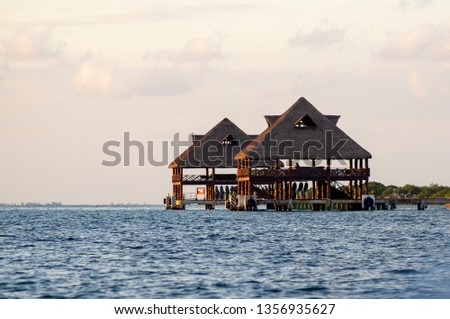 Tropical wooden harbour with thatched roof on Isla Mujeres during the sunset - Caribbean Sea 