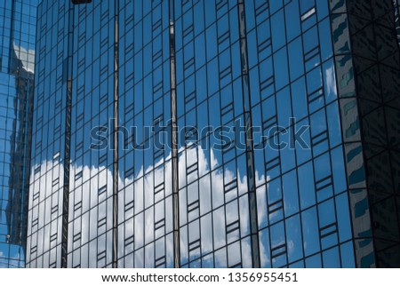 Glass and steel modern architecture pattern with reflection of cloud on the wall.   Shades of blue. Cells, geometric design.  