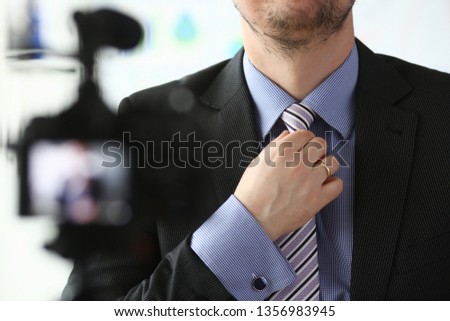 Male arm in blue suit set tie closeup on background web photo camera online show concept.
