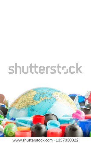 Conceptual and metaphorical photograph of a globe buried in plastic stoppers.