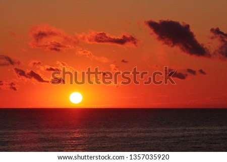 Orange cloudy sunrise over the ocean with sun flares
Lens flare refers to a phenomenon wherein light is scattered or flared in a lens system, often in response to a bright light.