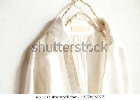 a blouse or shirt in white hanging on clothes hanger on white background.Close up.