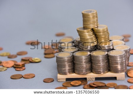 Stacks of EURO coins on wooden plate on clear background with out of focus effect